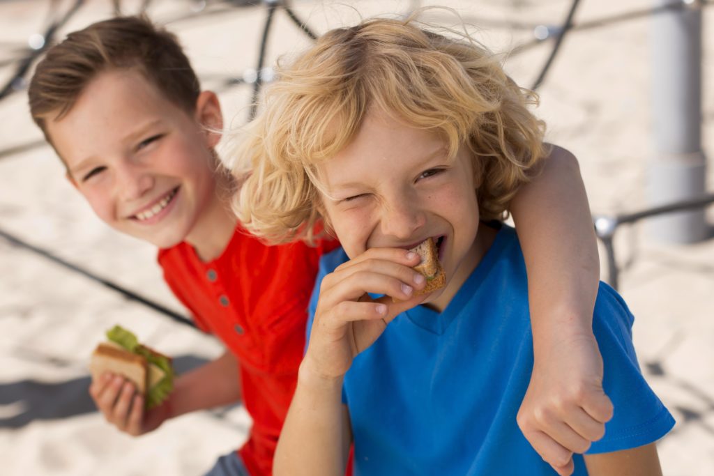 medium shot kids eating sandwich